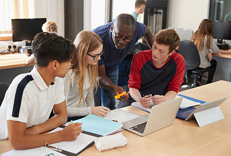 Students review a 3D printed part and discuss design improvements in a technical education lab. 3D Printing for Workforce Readiness